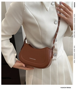 Gros plan du sac bandoulière demi-lune en cuir marron avec logo imprimé