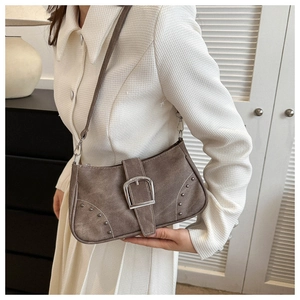Primer plano de bolso retro marrón con gran hebilla metálica plateada y detalles de tachuelas