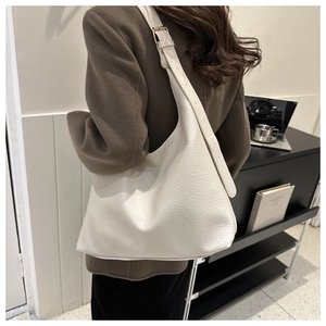 Detail of creamy white large hobo bag with lychee grain texture and gold metal buckle