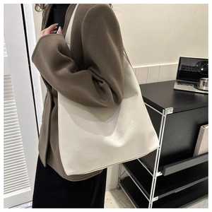Detailed macro view of white lychee pattern leather tote bag on female model