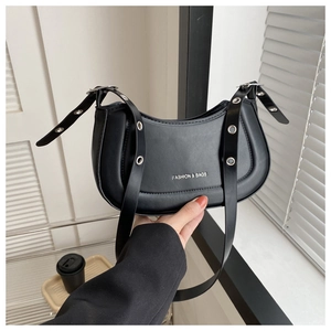 Détail du sac croissant noir avec œillets argentés et bandoulière réglable