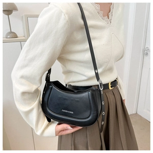 Détail du sac hobo noir avec bandoulière réglable et logo texte de mode blanc