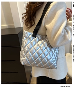 Silver quilted tote bag with diamond pattern shown on model in modern indoor setting