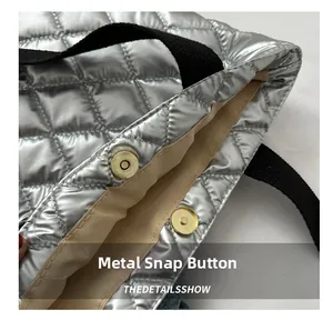 Close-up of magnetic closure and metallic silver quilted texture on high-end tote bag