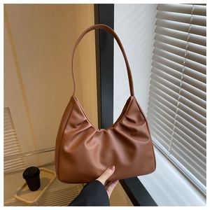 Detail der braunen gerafften Hobo-Bag auf einer Fensterbank mit Kaffeetasse