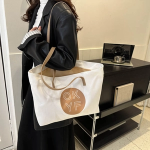 Minimalist white canvas tote bag with brown straps and circular print for women
