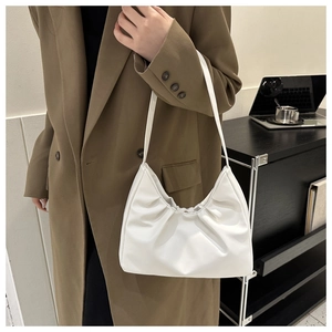 Schicke weiße Falten-Tasche am Modell in einem minimalistischen urbanen Büro-Setting