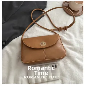 Brown faux leather crossbody bag with gold turn-lock closure and phone size comparison