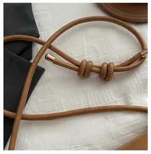 Detail of caramel leather shoulder strap with core padding and gold metal end caps