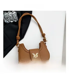 Brown leather shoulder bag featuring a golden butterfly buckle and knotted strap detail