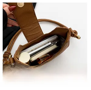 Internal capacity of brown pebble leather shoulder bag holding phone and cosmetics