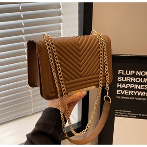 Detailed view of brown quilted PU leather crossbody bag with V-shaped stitching and gold chain