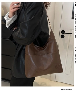 Dettaglio della borsa Hobo in pelle marrone scuro con tasca cucita su una modella