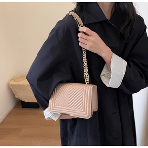 Detail of nude pink chevron quilted crossbody bag with vintage gold chain strap