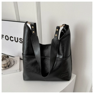 Dettaglio borsa tote in pelle PU nera con anelli di metallo dorato e rivetti decorativi