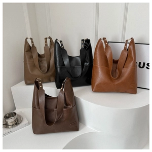Dettaglio di quattro grandi borse tote in pelle colorata con ampi spallacci e rivetti in metallo