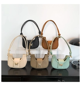 Detail view of five colors of leather underarm bags with metal butterfly clasps