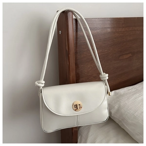 Elegant white crossbody bag with golden turn-lock and decorative knotted dual straps