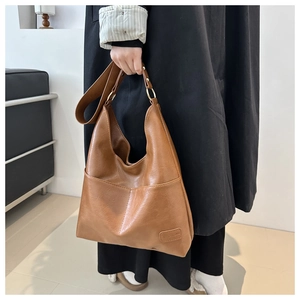 Dettaglio della borsa tote marrone con anelli dorati e finitura in pelle premium