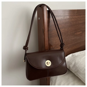 Dark brown leather vintage crossbody bag with a round gold twist lock and knotted strap