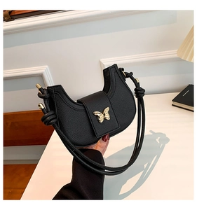 Black pebbled leather crescent underarm bag with gold butterfly buckle handle detail