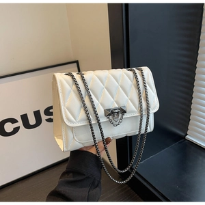 Dettaglio borsa a tracolla trapuntata bianca con catena gunmetal e chiusura a girello