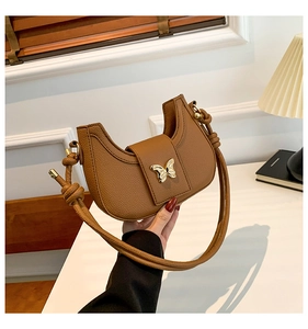 Brown litchi leather crescent shoulder bag with golden butterfly buckle and knot detail