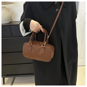 Close-up of brown PU leather handbag with embossed FASHION lettering and gold hardware