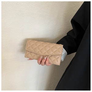 Detail of beige quilted faux leather wallet with diamond stitching and envelope flap
