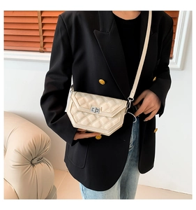 Détail du sac bandoulière matelassé blanc cassé avec fond asymétrique et fermoir argenté