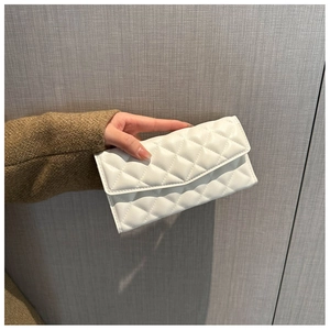 Close-up of white quilted faux leather wallet featuring a classic diamond stitch pattern