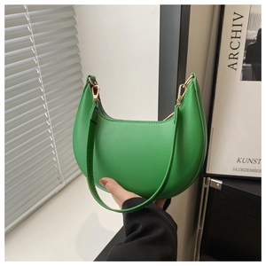 Vue détaillée du sac croissant vert vif avec ferrures dorées et bandoulière en cuir