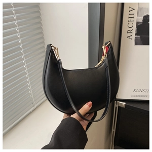 Détail du sac croissant noir avec fermeture éclair dorée et doublure rouge chic