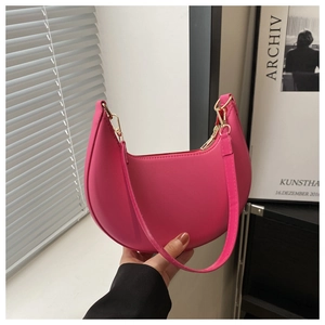 Détail d'un sac demi-lune rose vif avec ferrures dorées et texture en cuir élégante