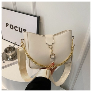 Détail du sac bandoulière crème avec chaîne dorée et large sangle en tissu minimaliste