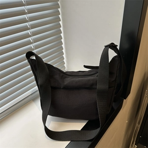 Minimalist black nylon hobo crossbody bag with wide adjustable shoulder strap