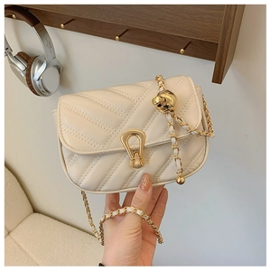 Detalle de bolso acolchado beige con cadena dorada y hebilla metálica esférica