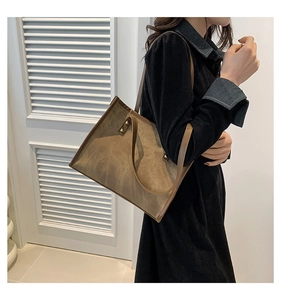 Side view of large vintage brown suede tote bag on shoulder with dark leather straps