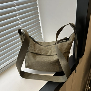 Olive green nylon tote bag with pleated texture and adjustable wide shoulder strap