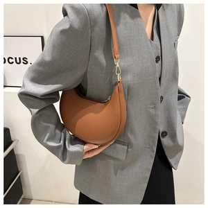 Détail du sac demi-lune marron caramel en similicuir lisse avec garnitures dorées