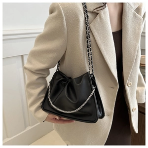 Close-up of black lychee leather bag featuring elegant silver chain and pleated design