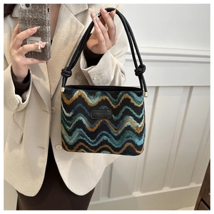 Detail of wool texture handbag with wavy patterns and twisted handle knot