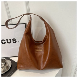 Detalle de bolso tote marrón oscuro con textura vintage y etiqueta de moda