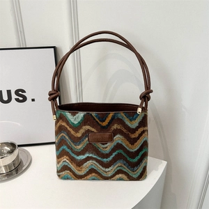 Vintage bucket bag with colorful wavy weave pattern and brown leather handle