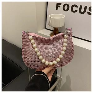 Detailed close-up of pink rhinestone hobo bag with white faux pearl handle and metal chain