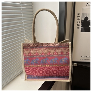 Detailed view of woven jute tote bag with ethnic elephant and red mandala patterns
