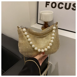 Macro view of gold sequin evening bag with sparkling rhinestones and pearl handle strap