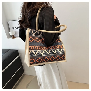 Detailed macro view of geometric ethnic pattern and thick hemp rope handle on tote bag