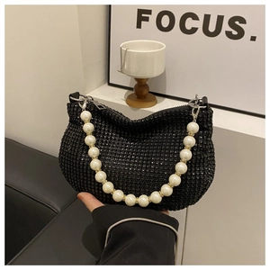 Detail of black rhinestone shoulder bag featuring an elegant faux pearl carry handle