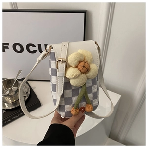 Détail du mini sac à bandoulière matelassé bleu avec décoration de fleur en peluche